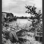 German Press Photo: Soldier in Foxhole with MG42 and Stug on the left